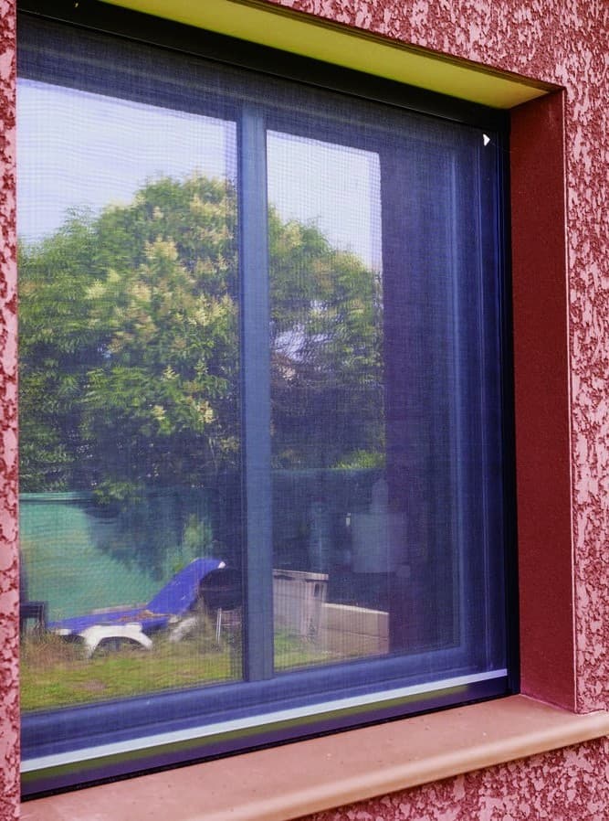 Moustiquaire enroulable posée sur une fenêtre aluminium