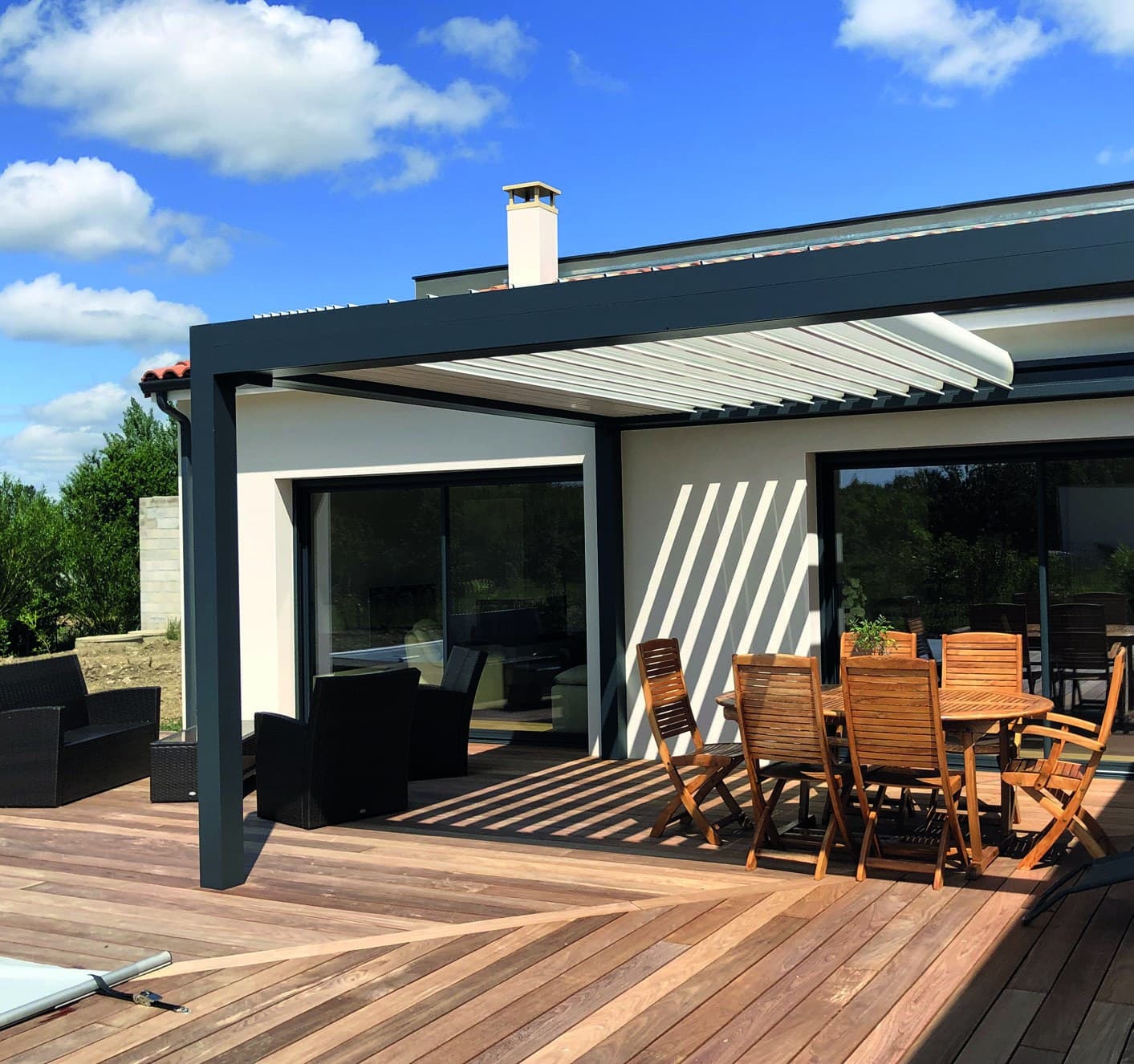 Pergola bioclimatique aluminium sur une terrasse en bois